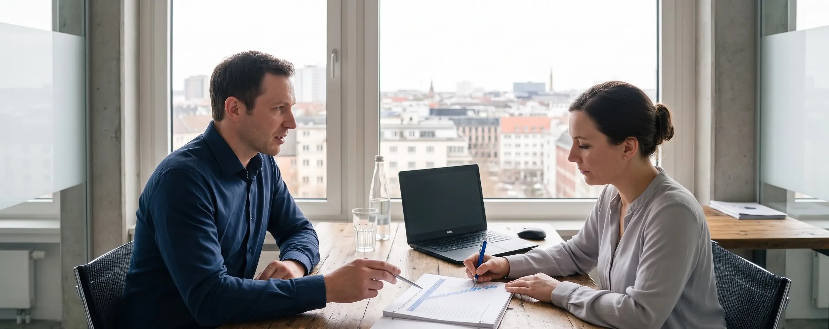 Besprechung an einem langen Tisch in einem hellen Raum